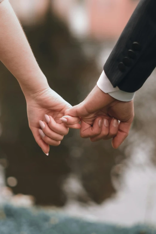 the bride and groom hold hands and hold their fingers