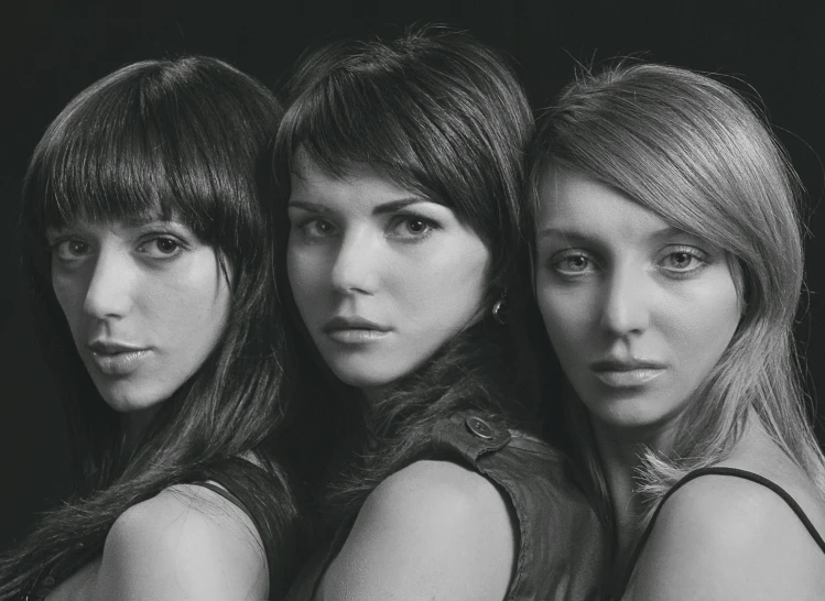 three woman pose for a po with one leaning on the other