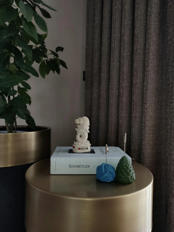 a table with a book on top of it next to a potted plant