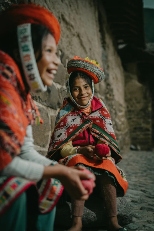 two women sitting on the ground with their heads wrapped up