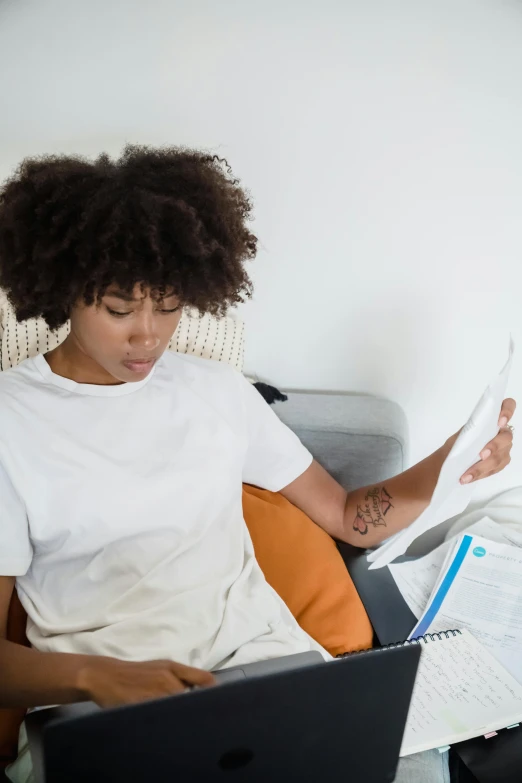 an african american girl with her laptop and papers