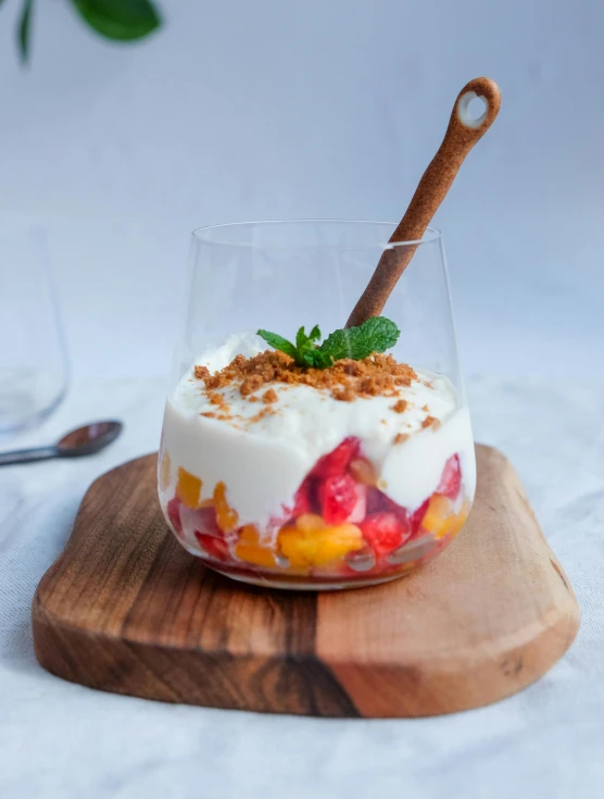 a dessert in a clear bowl and topped with fruit