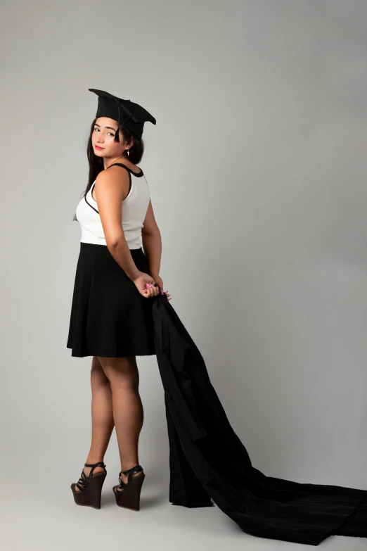 a girl in a graduation gown holding her graduation cap on