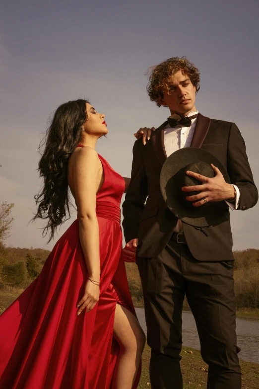 a man standing next to a woman in a red dress