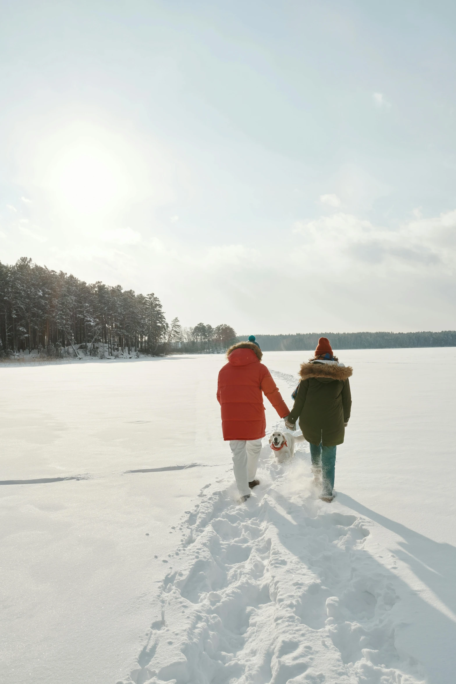 two people walk on a snow covered path