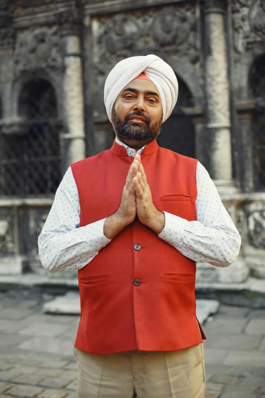 a man dressed in indian attire poses for the camera