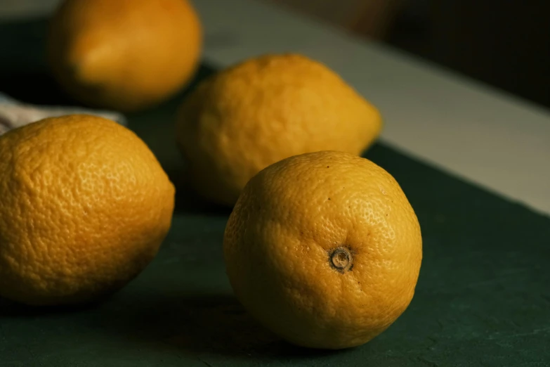 four oranges sit next to each other on a counter