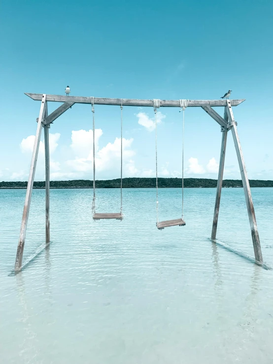 a swing made of wooden sticks in the water