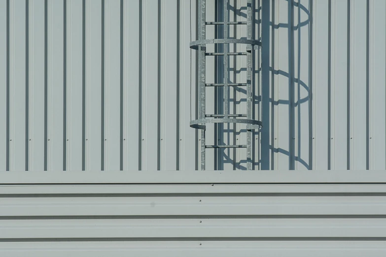 a bird sitting on the side of a metal building