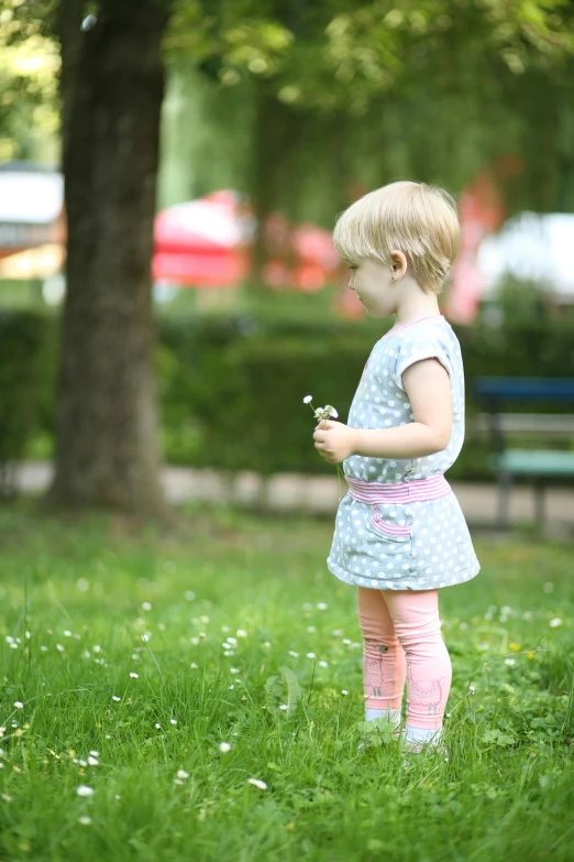 a little girl standing in a grassy field