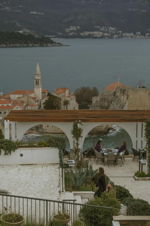 a man and woman sitting on a bench looking out over the water