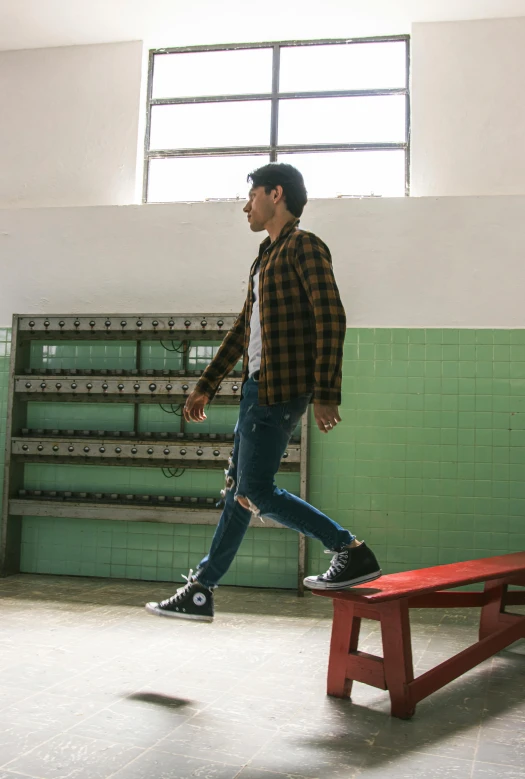 a man standing on top of a bench next to a wall