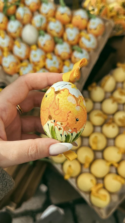 someone holding an ornament for a decorated easter egg