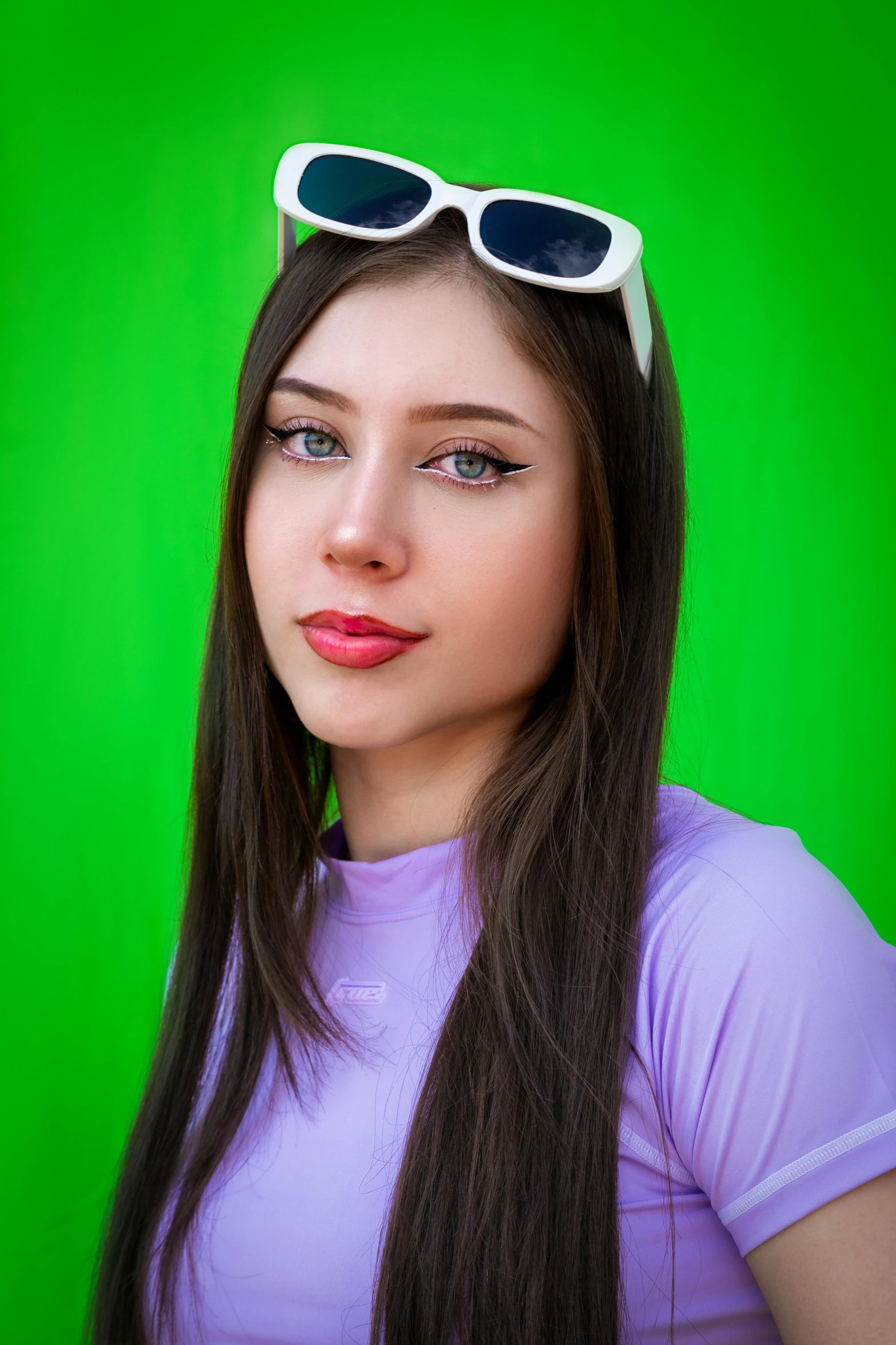 a girl wearing sun glasses and a pink t - shirt