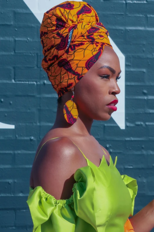 a woman is dressed in bright orange with green and yellow accessories