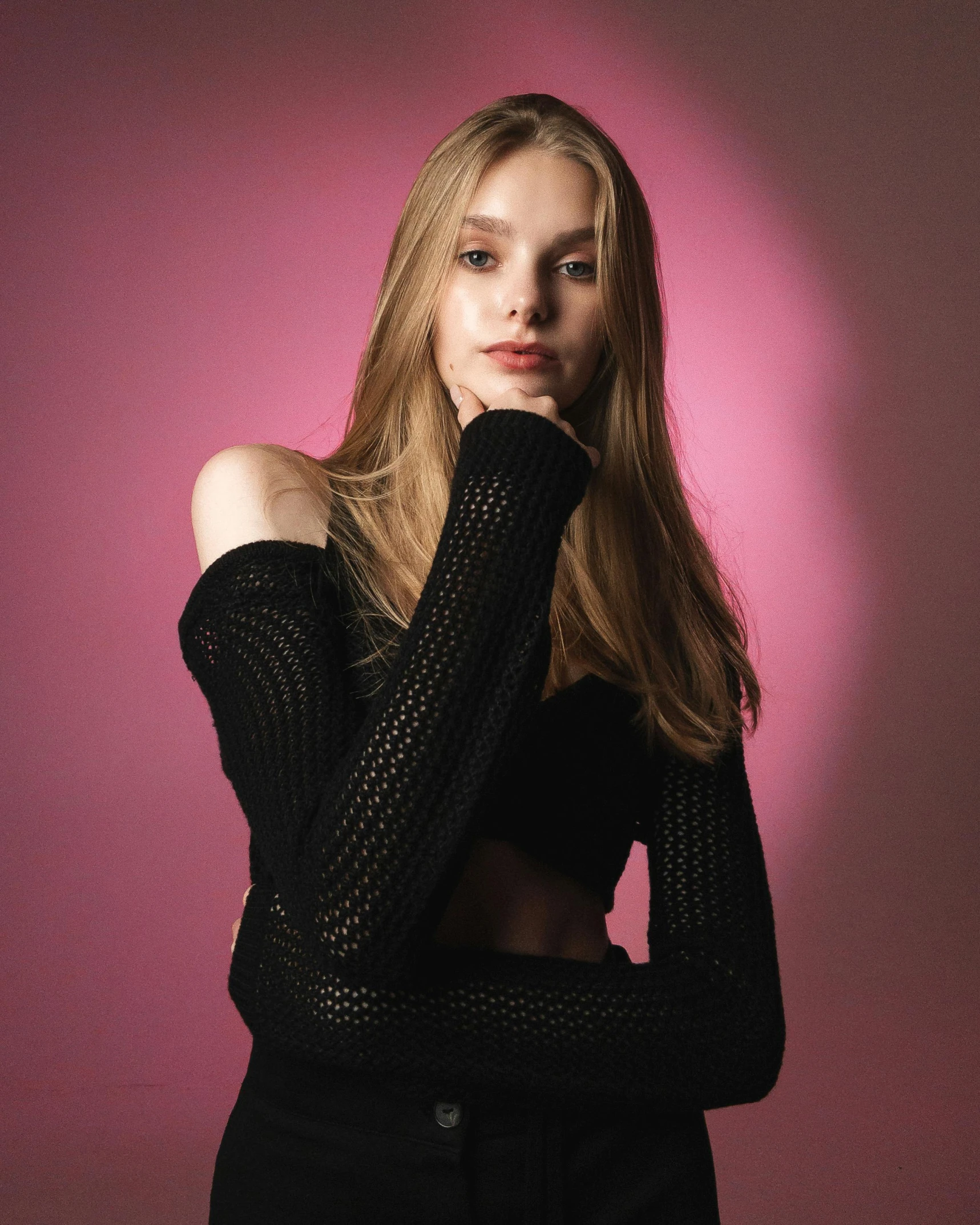 a woman in a black dress posing with her arms on her shoulder