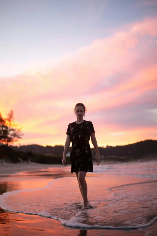 a woman walking out of the water on a beach