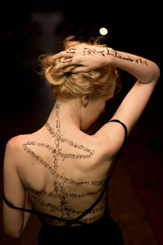 woman with writing on back and hand written poem