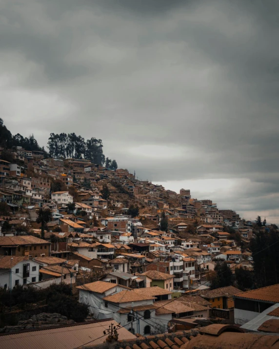 some houses are on a hill with dark clouds