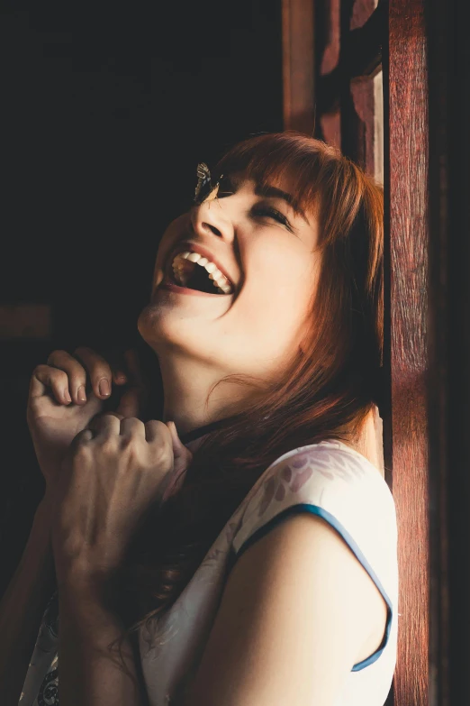 a beautiful red haired woman laughing in a doorway