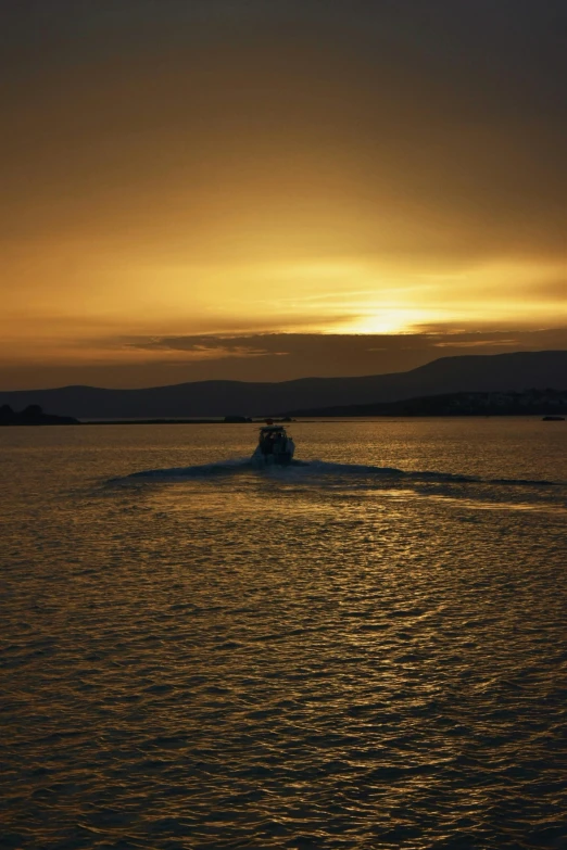 a boat out on a large lake as the sun sets