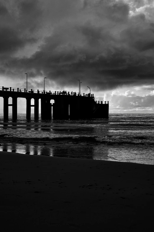 an old pier on the beach next to the ocean