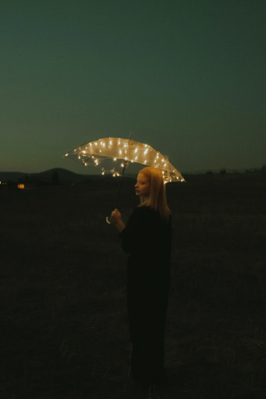 a person holding an umbrella with lights in the background