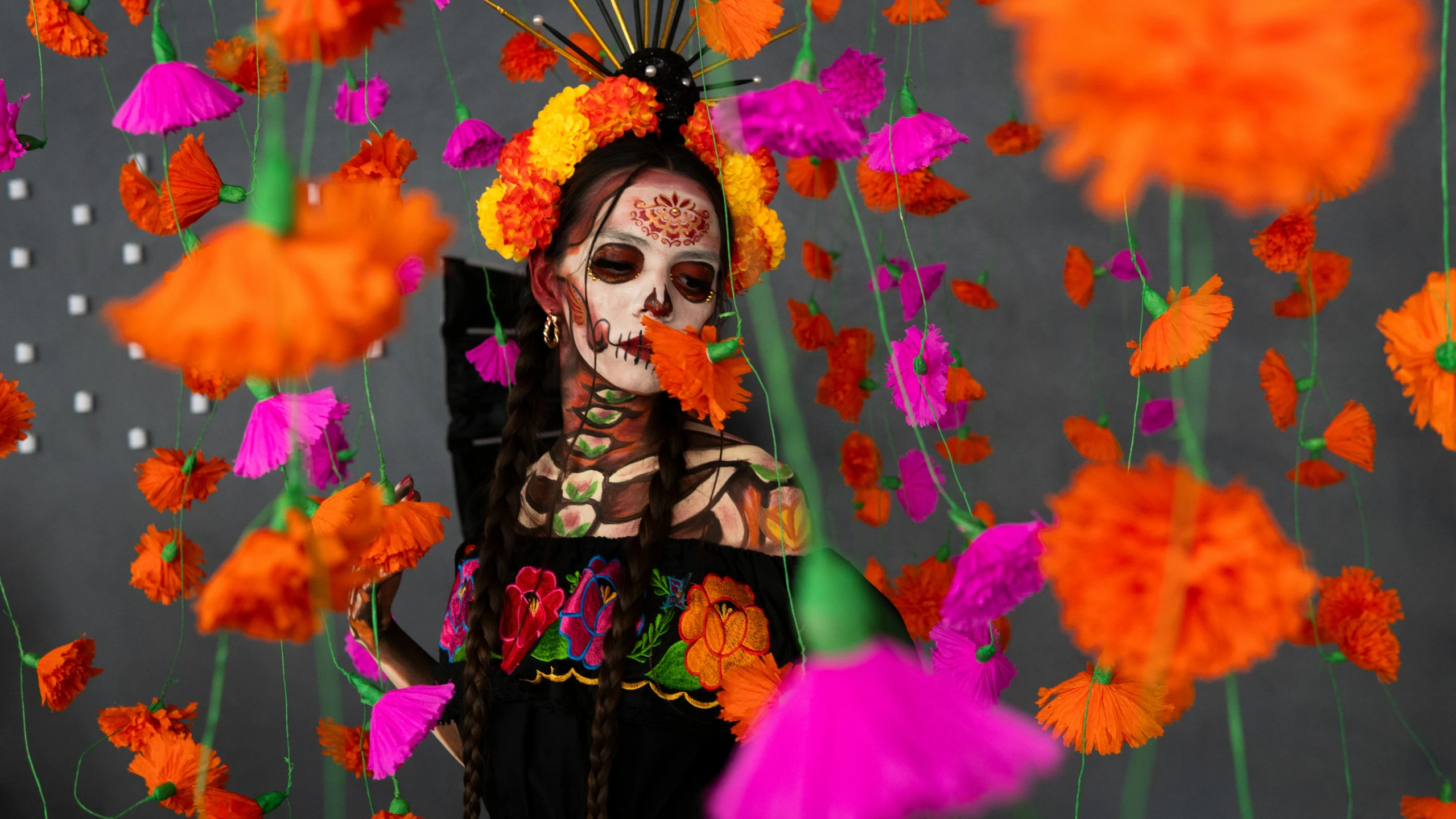 a woman with skeleton paint and flowers in the background