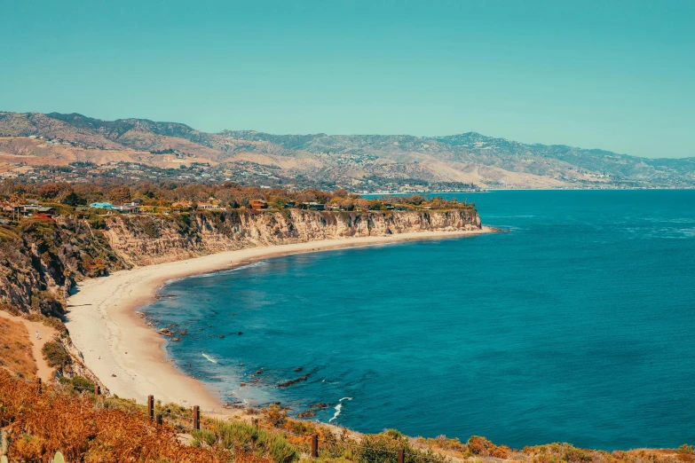 a beach near the shore with mountains in the background