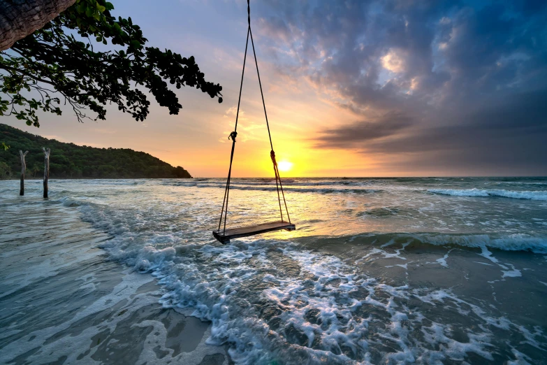 a beach swing sitting on the edge of a wave