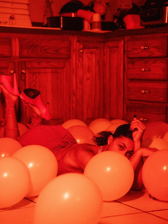 a woman lies on the floor with balloons in her hand