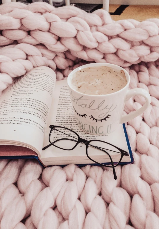 an open book sitting on top of a blanket