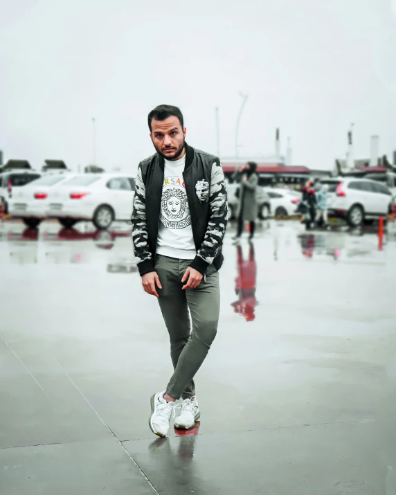 a man standing in a parking lot holding a skateboard