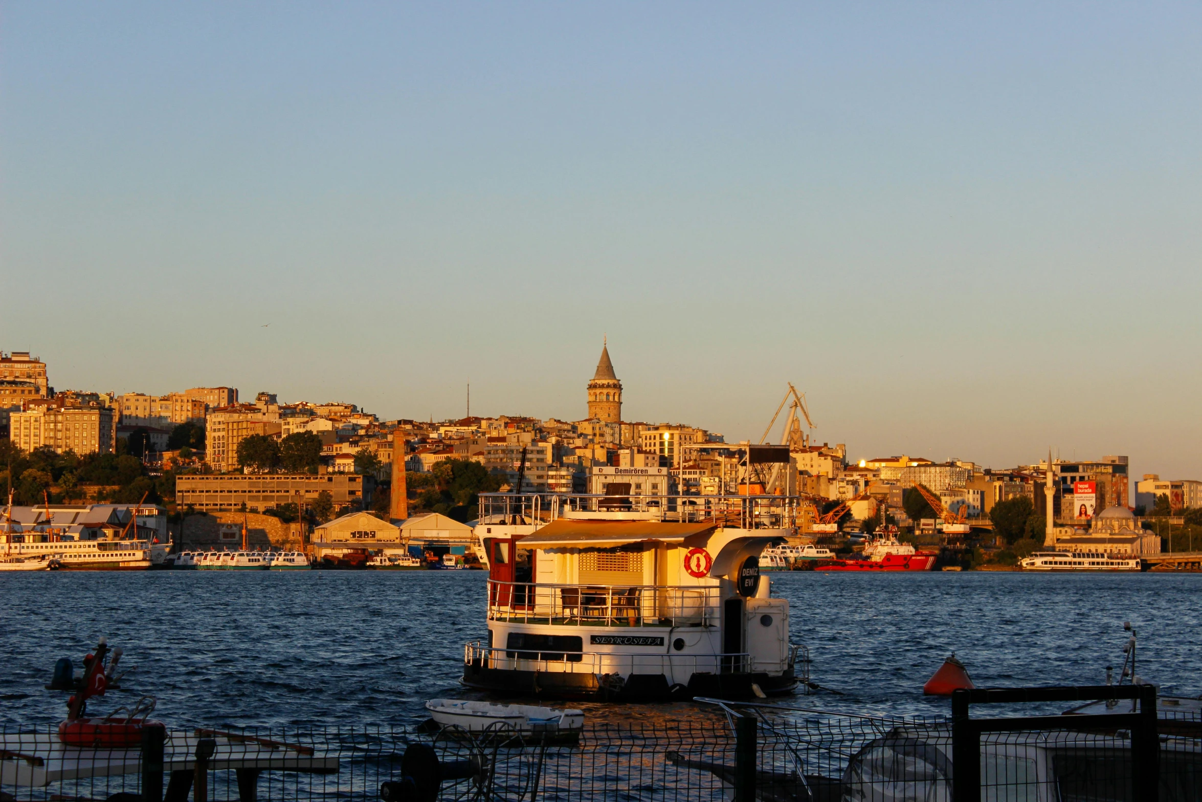 a boat sits parked on the water by a city