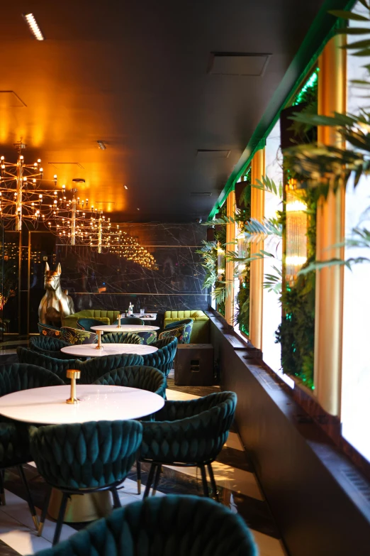 a restaurant with many tables and chairs in front of a wall that has lights on