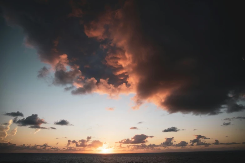 the sun shines brightly on the water below a partly cloudy sky