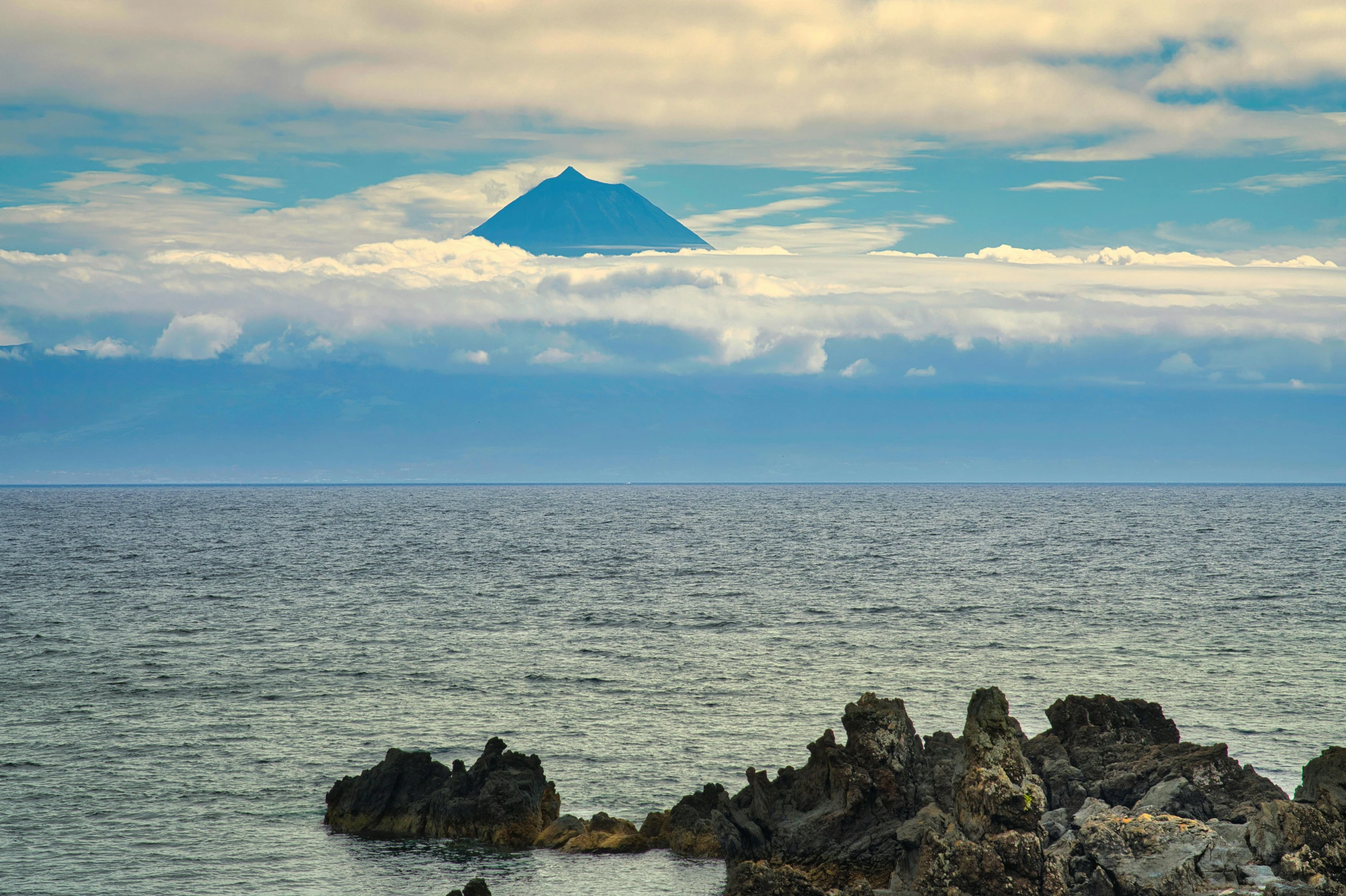 a small rocky outcropping in the ocean next to an island