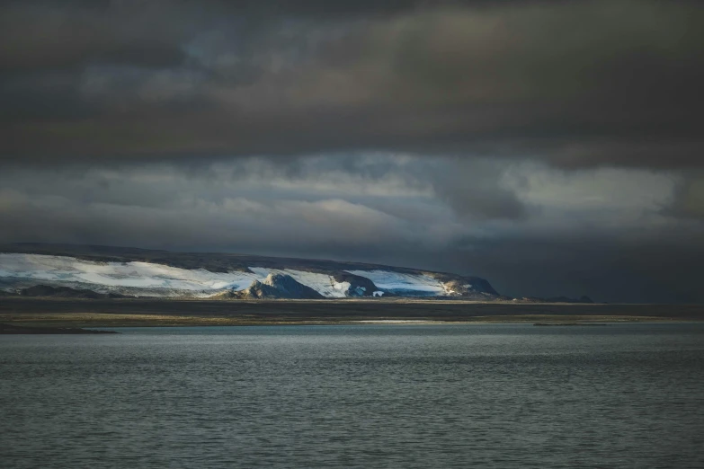 snow covered hills in the distance over a body of water