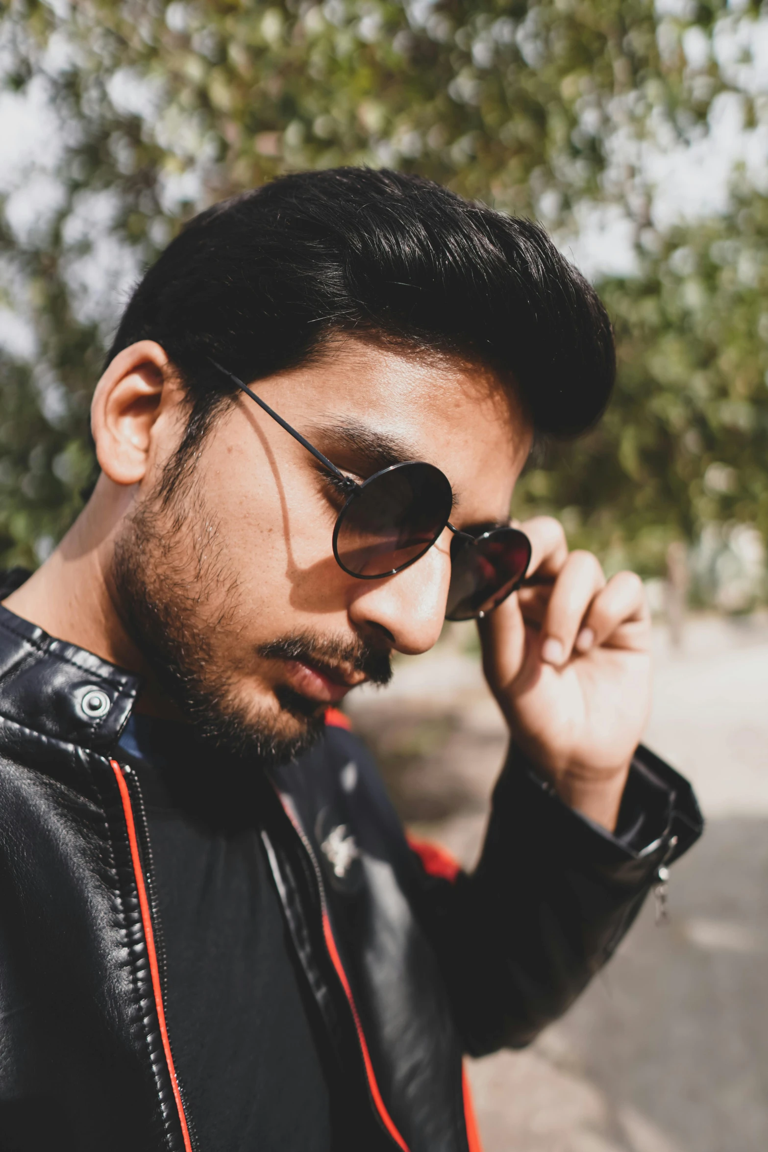 a young man is wearing sunglasses and staring off to the side