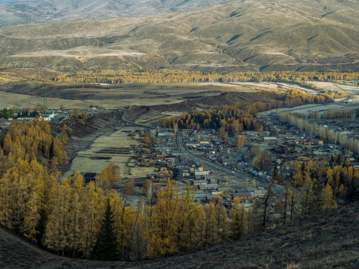 a small town sits on a hill, in the mountains