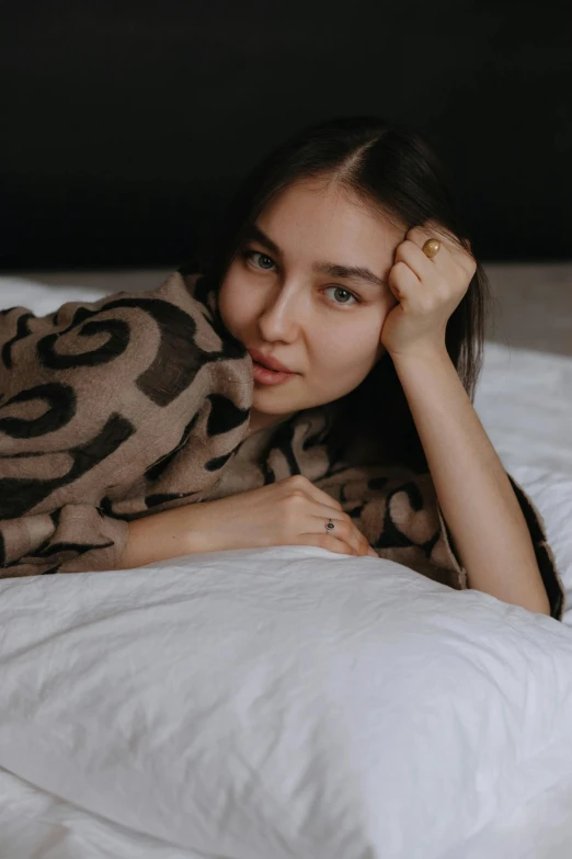 young lady lying in bed with white sheets