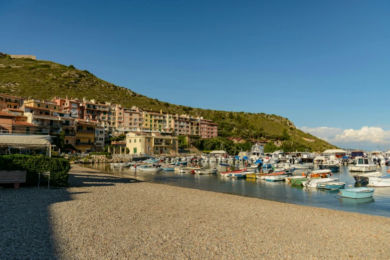 a harbor filled with lots of boats near a large hill