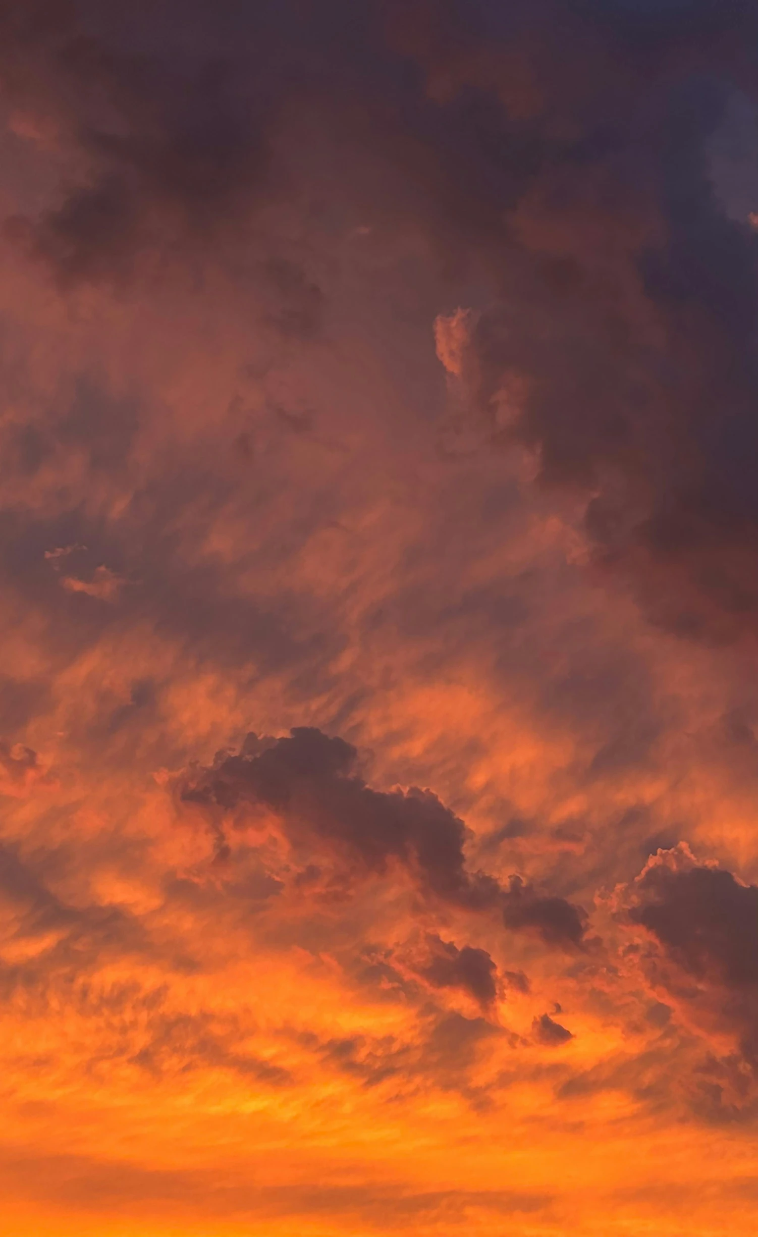 a jet flying by against an orange and blue sky