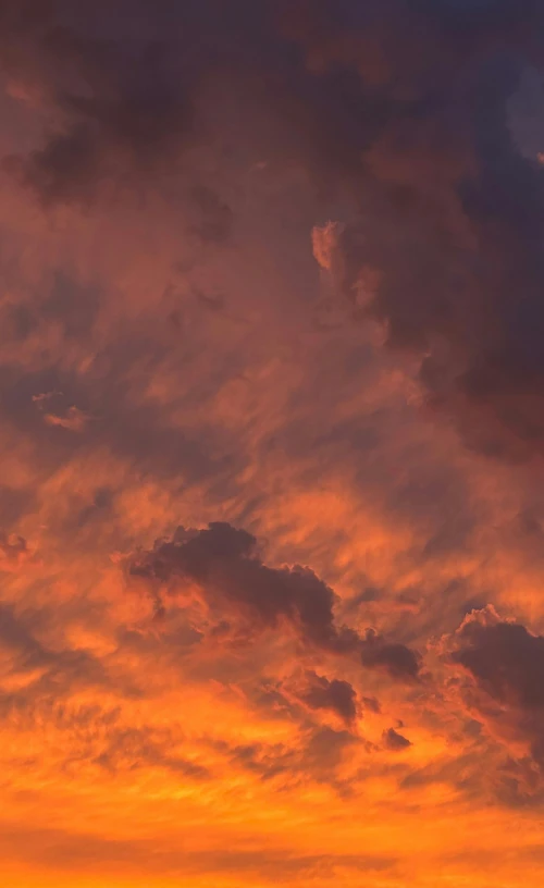 a jet flying by against an orange and blue sky