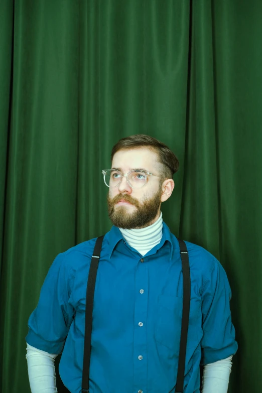 a bearded man posing with his legs crossed