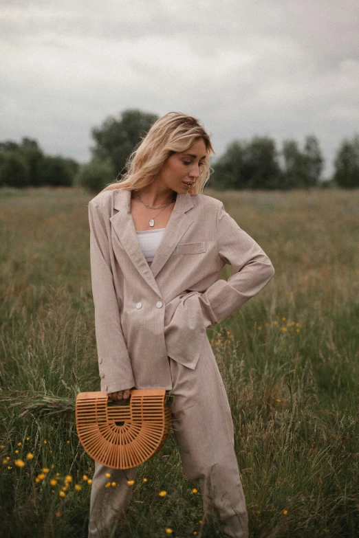 the woman is standing in the field posing for the camera