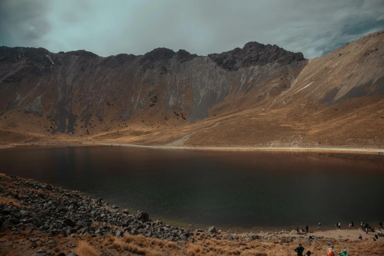 the mountains surround a pond on the side of the mountain