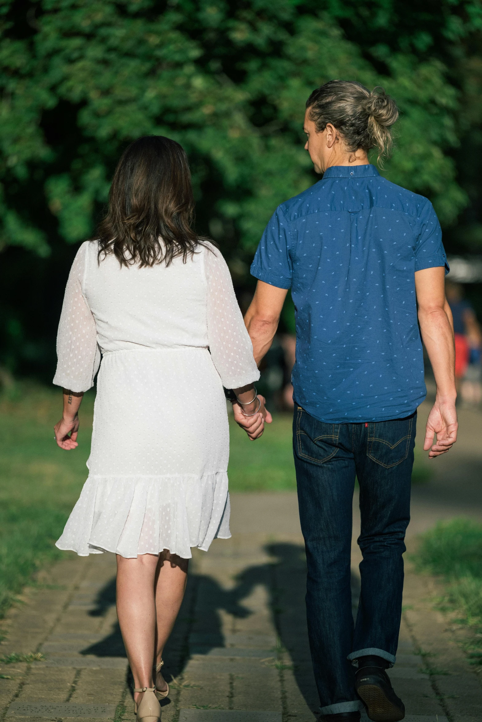 a man and a woman walking together holding hands