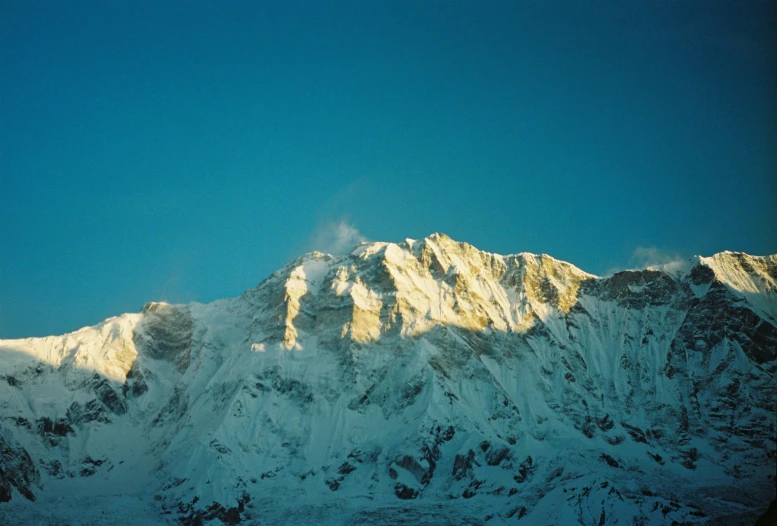 mountains covered in snow with some cloud cover