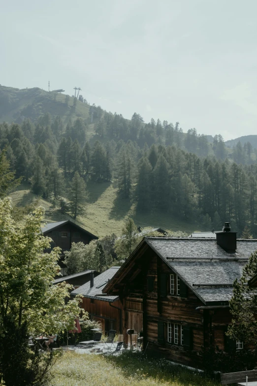 a wooden house in front of a mountain range